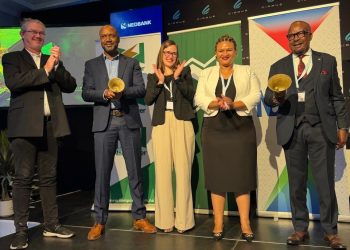 WhatsApp Image 2026-04-16 at 24508 PM | Mining and Energy Namibia | Namibia’s Leading Mining & Energy News Five professionals on a stage at an awards event, two men holding gold trophies while others applaud, backdrop banners visible.