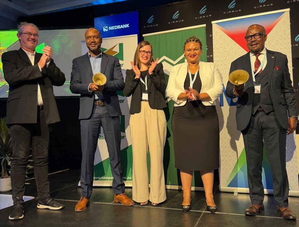 WhatsApp Image 2026-04-16 at 24508 PM | Mining and Energy Namibia | Namibia’s Leading Mining & Energy News Five professionals on a stage at an awards event, two men holding gold trophies while others applaud, backdrop banners visible.