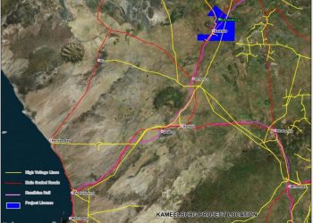 Map of the Kameelburg project area showing high-voltage lines (yellow), main sealed roads (red), Kamiblan rail (purple), and the project license area (blue box) with town labels and coast to the left.