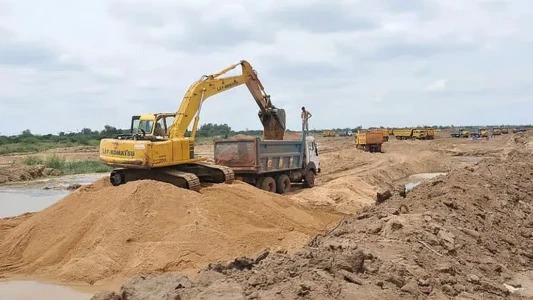 sand mining | Mining and Energy Namibia | Namibia’s Leading Mining & Energy News Yellow excavator loading sand into a dump truck at a dirt construction site, with more equipment lined up in the distance