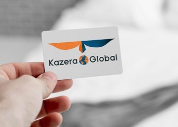 KAZERA | Mining and Energy Namibia | Namibia’s Leading Mining & Energy News Close-up of a hand holding a white business card displaying the Kazera Global logo (orange and blue wings with a globe) and text