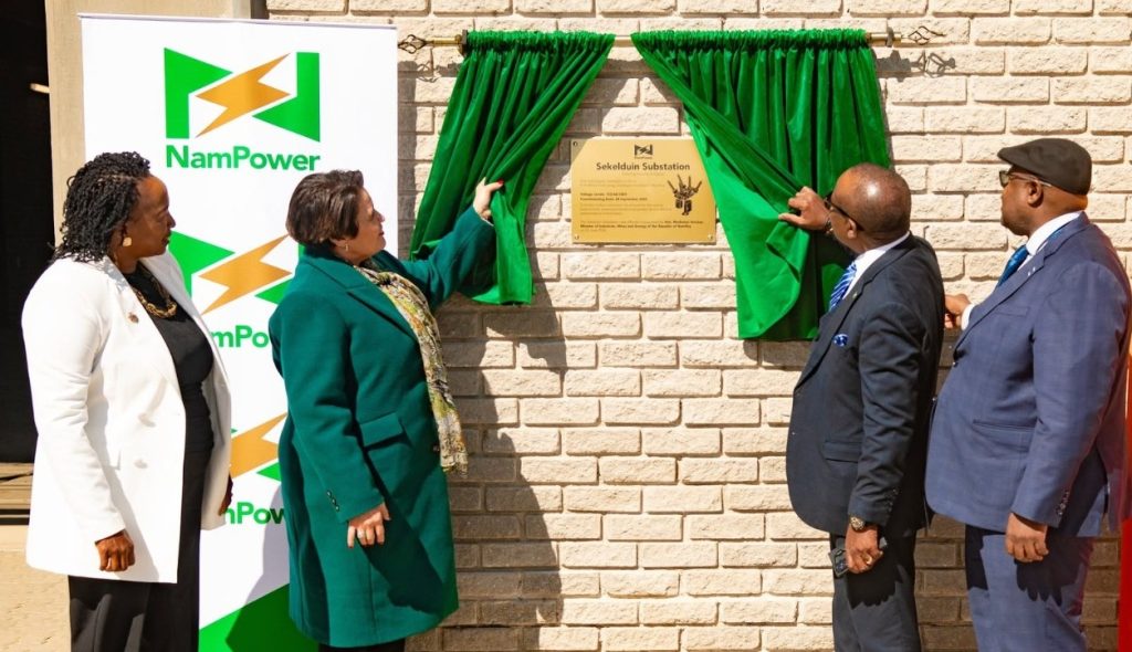 WhatsApp Image 2026-06-23 at 104254 AM | Mining and Energy Namibia | Namibia’s Leading Mining & Energy News Four officials unveil a bronze plaque on a brick wall while green curtains frame it, next to a NamPower banner.
