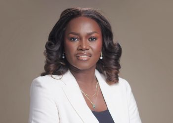 Saave Nakashole | Mining and Energy Namibia | Namibia’s Leading Mining & Energy News Professional portrait of a Black woman with shoulder-length curls, wearing a white blazer and jewelry, against a neutral background.