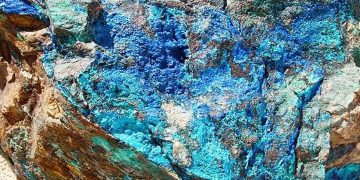 COPPER8 | Mining and Energy Namibia | Namibia’s Leading Mining & Energy News Close-up of a rugged rock surface with vibrant blue and teal mineral colors, likely copper minerals like azurite.