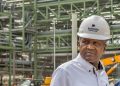 DANGOTE | Mining and Energy Namibia | Namibia’s Leading Mining & Energy News Man wearing a white hard hat with the Dangote Fertilizer logo at an industrial construction site.