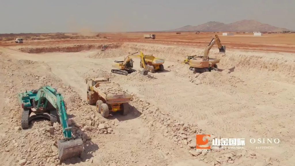 Osino Resources2 | Mining and Energy Namibia | Namibia’s Leading Mining & Energy News Open-pit mining site with multiple excavators and dump trucks on rocky terrain; OSINO logo bottom right.