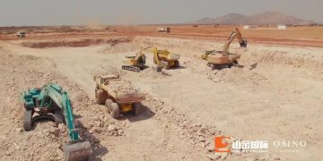 Open-pit mining site with multiple excavators and dump trucks on rocky terrain; OSINO logo bottom right.