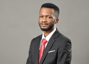 TIO NAKASOLE | Mining and Energy Namibia | Namibia’s Leading Mining & Energy News Portrait of a man in a black suit with a red tie, looking at the camera against a gray background.