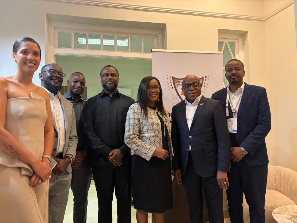 WhatsApp Image 2026-08-21 at 112425 AM | Mining and Energy Namibia | Namibia’s Leading Mining & Energy News Six professionals posing for a group photo indoors, wearing business attire, with a banner in the background featuring a crest/logo.