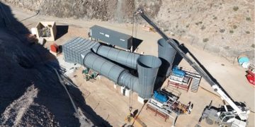 ROSH PINAH1 | Mining and Energy Namibia | Namibia’s Leading Mining & Energy News Industrial construction site with large gray cylindrical ducts and a crane lifting material on a dirt lot.