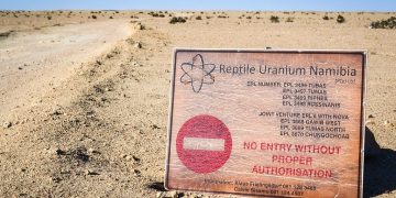 REPTILE URANIUM | Mining and Energy Namibia | Namibia’s Leading Mining & Energy News Desert landscape with a large weathered sign reading 'No entry without proper authorisation' for Reptile Uranium Namibia in the foreground.
