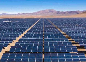 SOLAR PLANT | Mining and Energy Namibia | Namibia’s Leading Mining & Energy News Expansive desert solar farm with rows of blue solar panels stretching to the horizon under a clear blue sky.