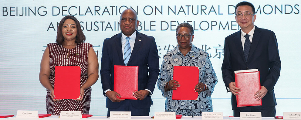 beijing-declaration-on-natural-diamonds-and-sustainable-development-signed-in-beijing-image-5 | Mining and Energy Namibia | Namibia’s Leading Mining & Energy News Four dignitaries stand behind a table, each holding a red folder at a signing ceremony for sustainable development goals in Beijing (Beijing Declaration on Natural Diamonds).