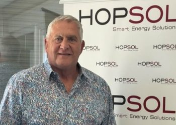 Andries Johannes Vermeulen | Mining and Energy Namibia | Namibia’s Leading Mining & Energy News Middle-aged man with gray hair and a patterned shirt posing in front of a HOPSOL banner that reads Smart Energy Solutions: a simple event photo portrait.