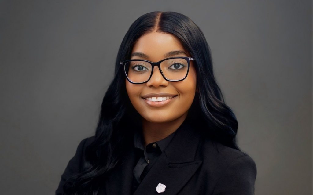 Wetu W Ishitile | Mining and Energy Namibia | Namibia’s Leading Mining & Energy News Professional headshot of a smiling woman with long black hair and glasses, wearing a black blazer against a gray backdrop.