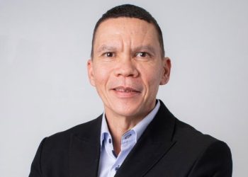 John Titus | Mining and Energy Namibia | Namibia’s Leading Mining & Energy News Professional headshot of a middle-aged man in a dark blazer and light blue shirt against a light gray background, smiling subtly.