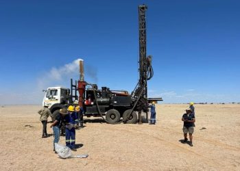 Elevate-Uranium-ASX-EL8-increases-drilling-operation-Koppies-project-Namibia-Africa | Mining and Energy Namibia | Namibia’s Leading Mining & Energy News Mobile drilling rig mounted on a truck in a flat desert, workers in hard hats and coveralls nearby.