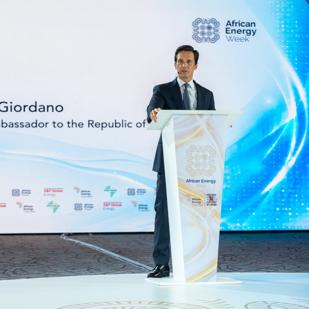 John Giordano1 | Mining and Energy Namibia | Namibia’s Leading Mining & Energy News Man in a dark suit delivering a speech at a podium during African Energy Week conference.
