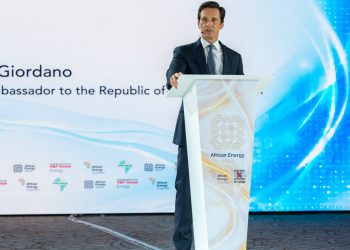 Man in a dark suit delivering a speech at a podium during African Energy Week conference.